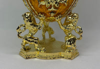 Gold decorative egg with lion figures holding the faberge type egg